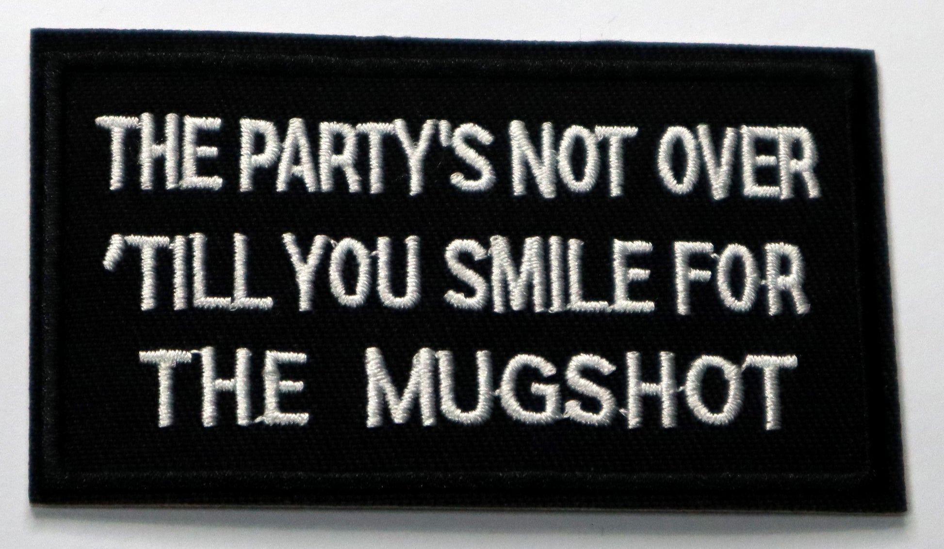 The party's not over until you smile for the mugshot Iron On Patch. Great for attaching to your jackets, shirts, pants, jeans, hats.  Size: 9.2x5.3cm